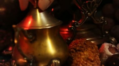 Bardağa eller ile oryantal takı çay yapma. Geleneksel Fas tatlılar. Safran Masala süt çay fincan