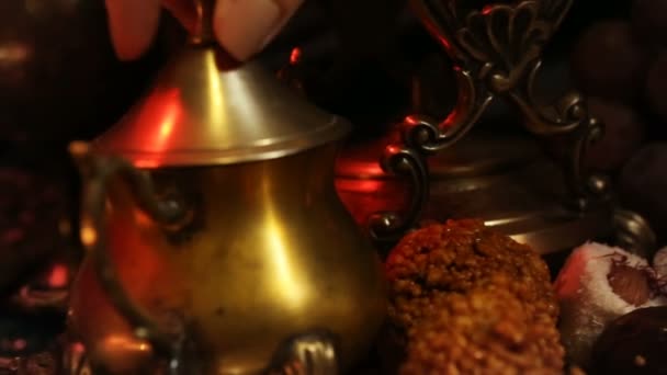 Mani femminili con gioielli orientali Fare il tè in tazza. Dolci tradizionali marocchini. Tazza di tè al latte allo zafferano Masala — Video Stock