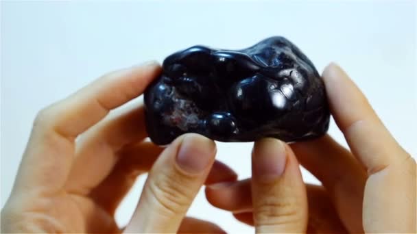 La hematita (hematita) es la forma mineral negra del hierro. Joyero sosteniendo hematita — Vídeo de stock