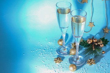 Noel havası. Şampanya ile bardaklar. Yeni yıl. Noel ağacı süslemeleri, kozalaklı dallar. Boşluğu kopyala. 