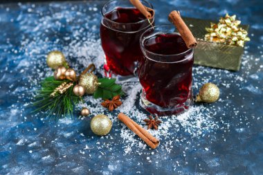 Noel şarabı, baharatlı ve koyu arkaplanda sıcak şarap. Beyaz karın etrafında. Yeni yıl. Noel süsleri, tarçın çubukları. Boşluğu kopyala. 