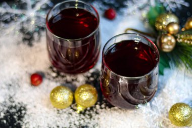 Noel şarabı, baharatlı ve koyu arkaplanda sıcak şarap. Beyaz karın etrafında. Yeni yıl. Noel süsleri, tarçın çubukları. Boşluğu kopyala. 