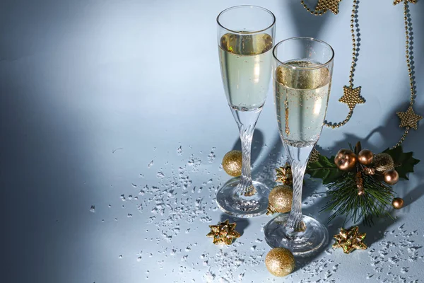 Noel havası. Şampanya ile bardaklar. Yeni yıl. Noel ağacı süslemeleri, kozalaklı dallar. Boşluğu kopyala. 