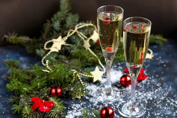 Noel havası. Şampanya ile bardaklar. Yeni yıl. Noel ağacı süslemeleri, kozalaklı dallar. Boşluğu kopyala. 