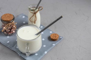 Kefir, probiyotiklerle mayalanmış bir içecek. Faydalı ve modaya uygun ekşi süt yiyecekler ve içecekler. Hafif arkaplan. Kağıt tüp. Boşluğu kopyala. 