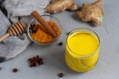 Baharatlı altın süt. Zerdeçal, karanfil, karabiber ve bir damla bitkisel yağ. Geleneksel Hint içkisi. Hafif bir arkaplanda. Sağlıklı yeme alanı kopyala. 