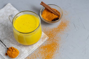 Baharatlı altın süt. Zerdeçal, karanfil, karabiber ve bir damla bitkisel yağ. Geleneksel Hint içkisi. Hafif bir arkaplanda. Sağlıklı yeme alanı kopyala. 