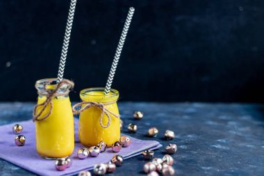 Baharatlı altın süt. Zerdeçal, karanfil, karabiber ve bir damla bitkisel yağ. Geleneksel Hint içkisi. Karanlık bir arka planda. Sağlıklı yeme alanı kopyala. 