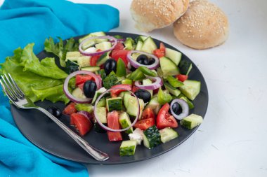 Yunan salatası. Doğranmış domates, salatalık, peynir, zeytin. Kırmızı soğan halkaları. Vejetaryenler için yemek. Şenlikli ve yeni yıl yemeği. Hafif bir arkaplanda. Boşluğu kopyala. 