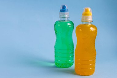 Sağlıklı bir diyet için taze meyve suyu. İzotonik, enerji içeceği. İki renkli su şişesi, bir spor içeceği. Su dengesini sağlıyor. Boşluğu kopyala. 