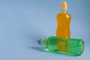 Sağlıklı bir diyet için taze meyve suyu. İzotonik, enerji içeceği. İki renkli su şişesi, bir spor içeceği. Su dengesini sağlıyor. Boşluğu kopyala. 