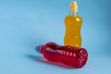 Sağlıklı bir diyet için taze meyve suyu. İzotonik, enerji içeceği. İki renkli su şişesi, bir spor içeceği. Su dengesini sağlıyor. Boşluğu kopyala. 