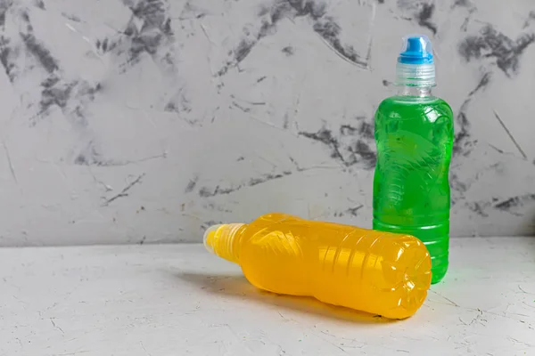 Sağlıklı bir diyet için taze meyve suyu. İzotonik, enerji içeceği. İki renkli su şişesi, bir spor içeceği. Su dengesini sağlıyor. Boşluğu kopyala. 