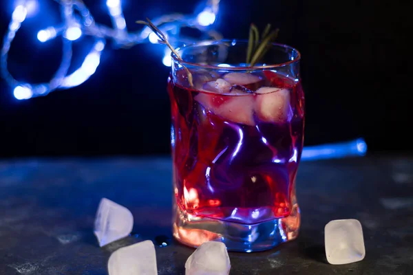 Celebratory drink, rose wine on a dark background. New Year's props, artificial snow. Copy space.