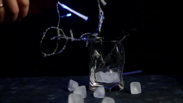 Πρωτοχρονιάτικο Ποτό Χύνεται Ένα Διαφανές Ποτήρι Μπλε Φώτα Είναι Αναμμένα — Αρχείο Βίντεο