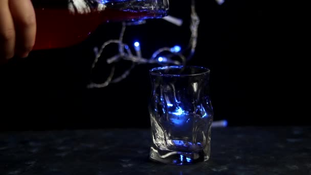 Новогодний Напиток Наливают Прозрачное Стекло Голубые Огни Горят Сзади Темный — стоковое видео