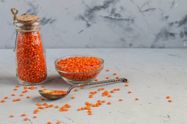 Tabakta kırmızı mercimek ve betonun altında metal bir kaşıkta. Vejetaryenler için ideal yiyecek..