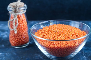 Tabakta kırmızı mercimek ve betonun altında metal bir kaşıkta. Vejetaryenler için ideal yiyecek..