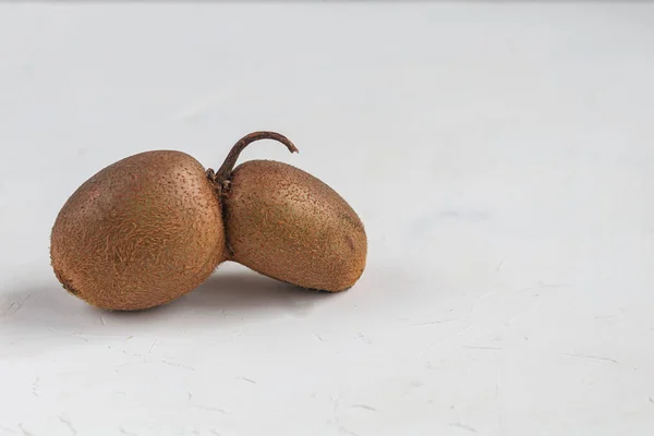A fruta de kiwi feia. Saboroso e saudável. Comida vegetariana. Em um fundo claro . — Fotografia de Stock