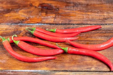 Ahşap bir yüzeyde acı kırmızı biber. Yemeklerde baharatlı katkı maddesi..