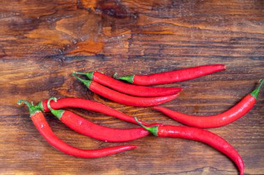 Ahşap bir yüzeyde acı kırmızı biber. Yemeklerde baharatlı katkı maddesi..