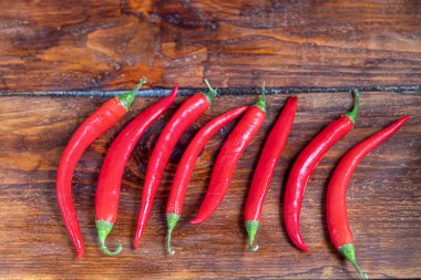 Ahşap bir yüzeyde acı kırmızı biber. Yemeklerde baharatlı katkı maddesi..