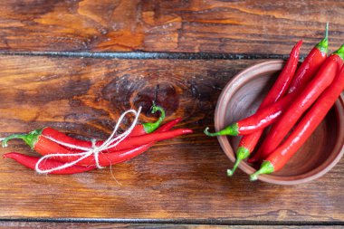 Ahşap bir yüzeyde acı kırmızı biber. Yemeklerde baharatlı katkı maddesi..
