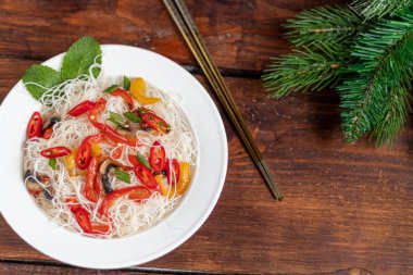Doğu usulü pirinç eriştesi, Udon, tatlı biber ve mantar. Ahşap bir arka planda.