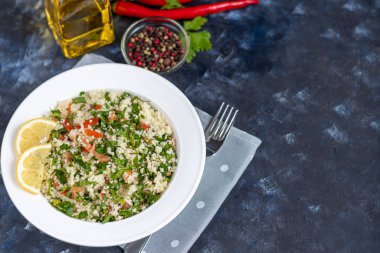 Beyaz tabakta Tabbouleh salatası koyu mavi, modaya uygun arka plan 2020.