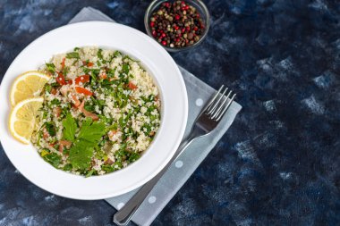 Beyaz tabakta Tabbouleh salatası koyu mavi, modaya uygun arka plan 2020.