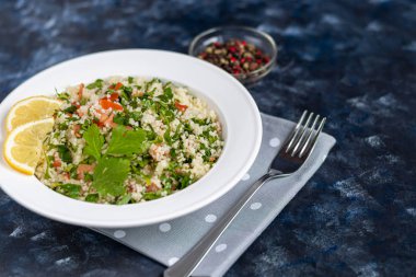 Beyaz tabakta Tabbouleh salatası koyu mavi, modaya uygun arka plan 2020.