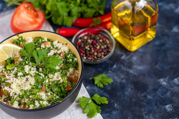 Tabbouleh-Salat in einem runden Teller auf dunkelblauem Hintergrund. — Stockfoto