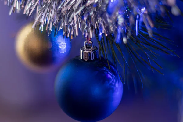 Weihnachtsbaum geschmückt mit Spielzeug und Funkeln. vor dem Hintergrund von Blau, Trend 2020. — Stockfoto