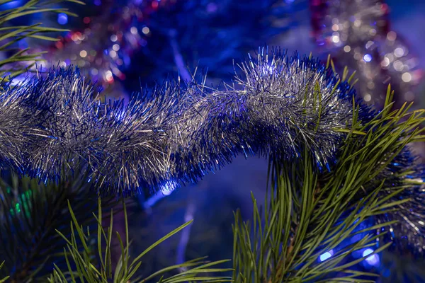 Kerstboom versierd met speelgoed en sprankelingen. Tegen de achtergrond van blauw, trend 2020. — Stockfoto