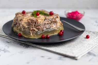 Et, domuz eti ve tavuklu jöle, sarımsaklı. Geleneksel Rus yemeği, siyah bir tabakta yaban turpunun yanında servis edilir..