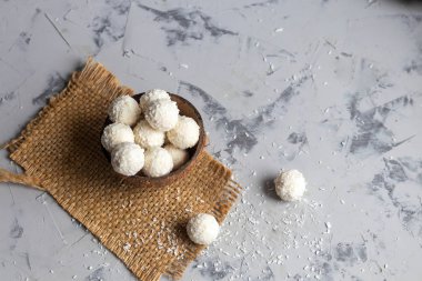 Hindistan cevizi taneli şekerler ve gri taşlı arka planda keten tohumlu taze hindistan cevizi. Enerji topları.