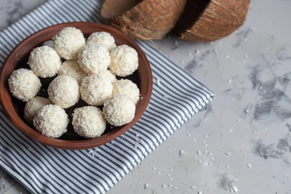 Caramelos en copos de coco y coco fresco con semillas de lino sobre un fondo de piedra gris. Bolas de energía . — Foto de Stock