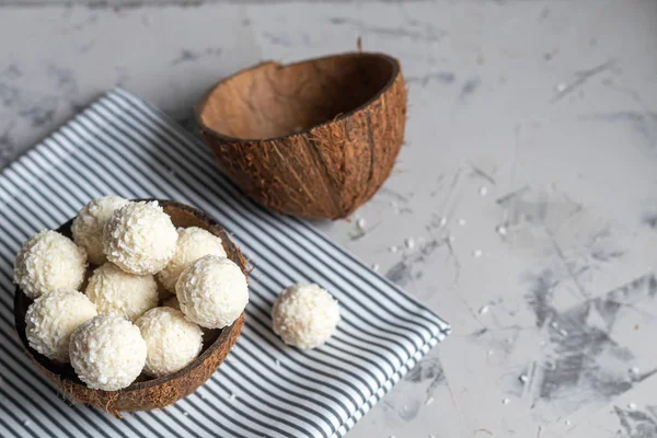 Caramelos en copos de coco y coco fresco con semillas de lino sobre un fondo de piedra gris. Bolas de energía . — Foto de Stock