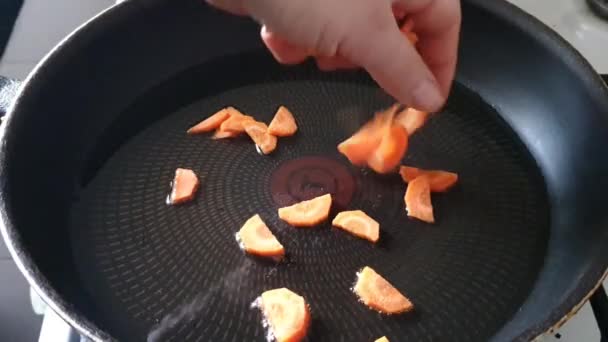 We clean the carrots and prepare for frying. We cut it into thin slices and put it in a transparent, glass bowl. — Stock Video