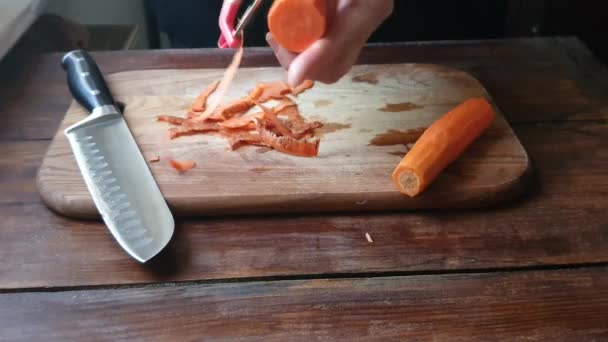 Czyścimy marchewki i przygotowujemy się do smażenia. Kroimy go na cienkie plasterki i wkładamy do przezroczystego. — Wideo stockowe