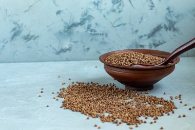 Karabuğday, orta pişmiş. Yulaf lapası yapmak için ölçülmüş. Betonun altındaki gri arka planda.