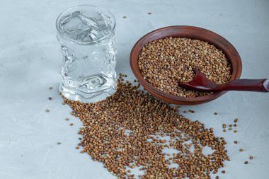 Karabuğday, orta pişmiş. Yulaf lapası yapmak için ölçülmüş. Betonun altındaki gri arka planda.