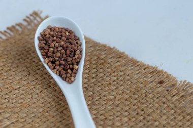 Karabuğday, orta pişmiş. Yulaf lapası yapmak için ölçülmüş. Betonun altındaki gri arka planda.