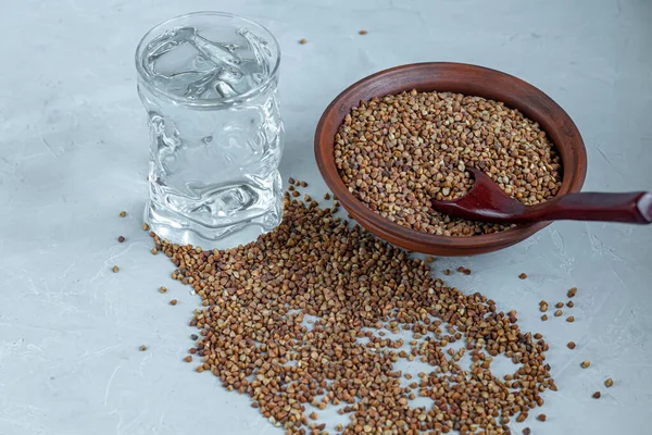 Karabuğday, orta pişmiş. Yulaf lapası yapmak için ölçülmüş. Betonun altındaki gri arka planda.