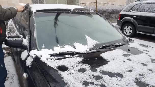 雪が降っていた車を掃除する 冬の寒い朝 駐車場の黒い車 — ストック動画