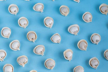 Açık mavi arka planda çiğ, donmuş hamur köfteleri deseni..