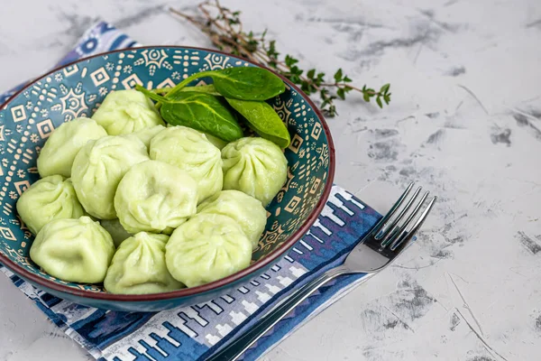 Гінкалі варили з тіста зі шпинату. Одягнені у Red Chilli, Dill і Parsley. На світло-сірому фоні під — стокове фото