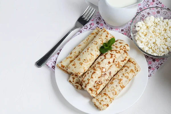 Palačinky s domácím tvarohem. Kvašený produkt z kyselého mléka. Zdravé, lahodné snídaně. S kyselou smetanou a malinovou marmeládou. — Stock fotografie