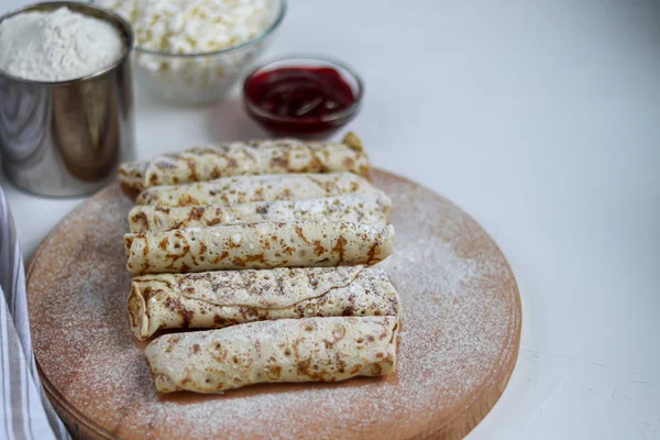 Syrové palačinky s domácím tvarohem. Kvašený produkt z kyselého mléka. Zdravé, lahodné snídaně. Na dřevěné desce. — Stock fotografie