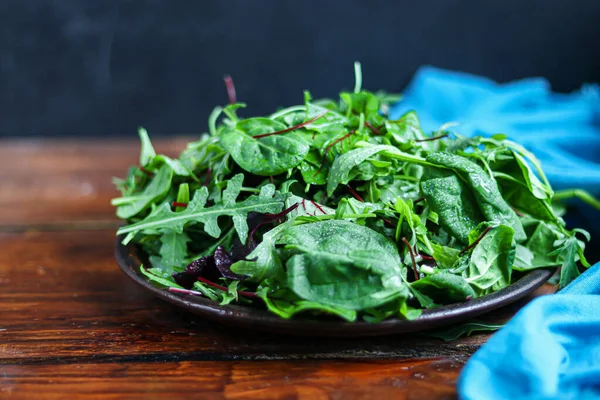 Una mezcla de lechuga verde joven, espinacas, rúcula y remolacha joven. Dieta saludable. Desayuno vegetariano. Sobre un fondo oscuro . —  Fotos de Stock